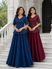 Two women in blue and maroon traditional outfits standing on steps.