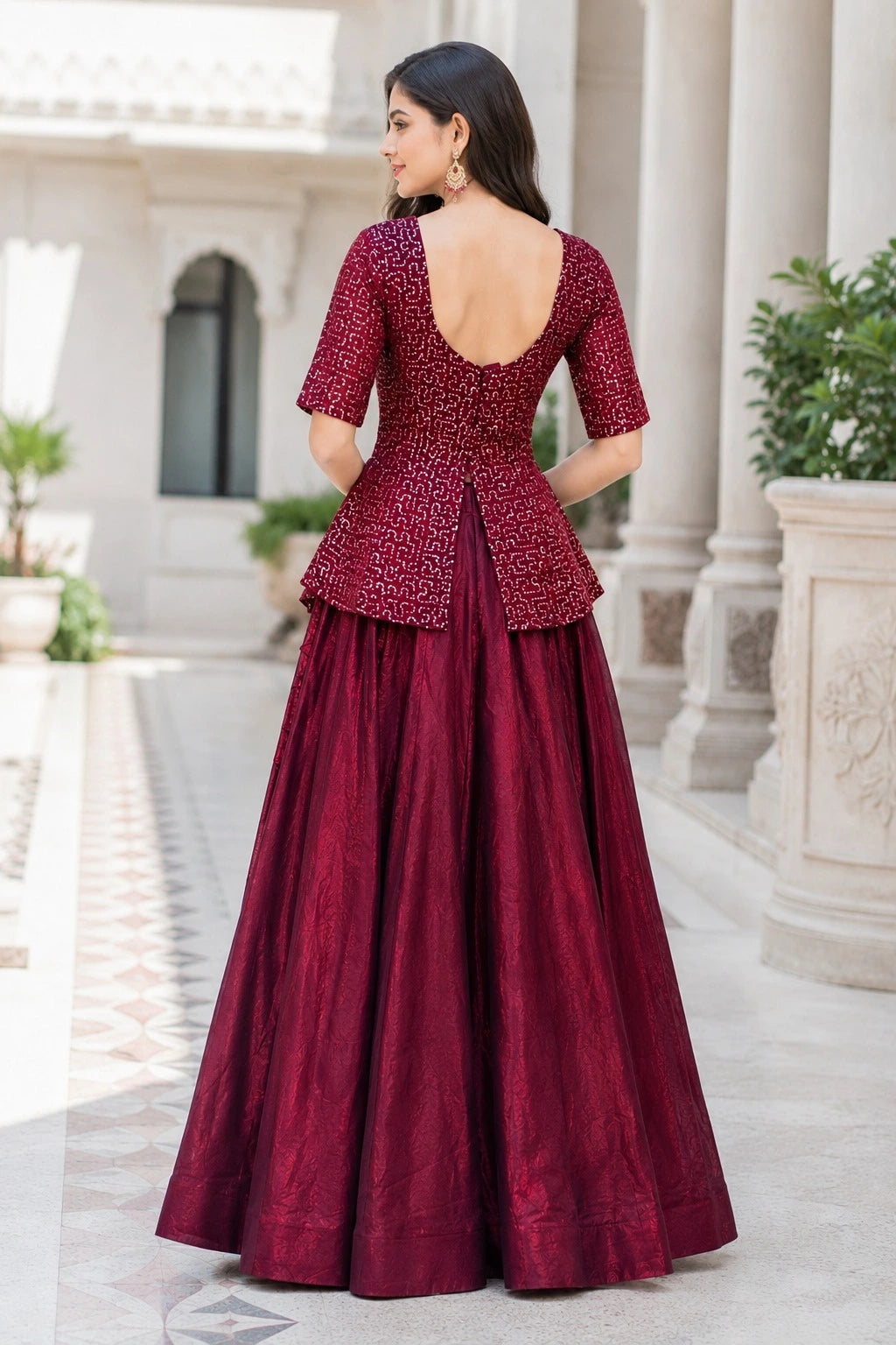 Woman wearing a burgundy traditional outfit with a peplum top and long skirt in an outdoor setting.