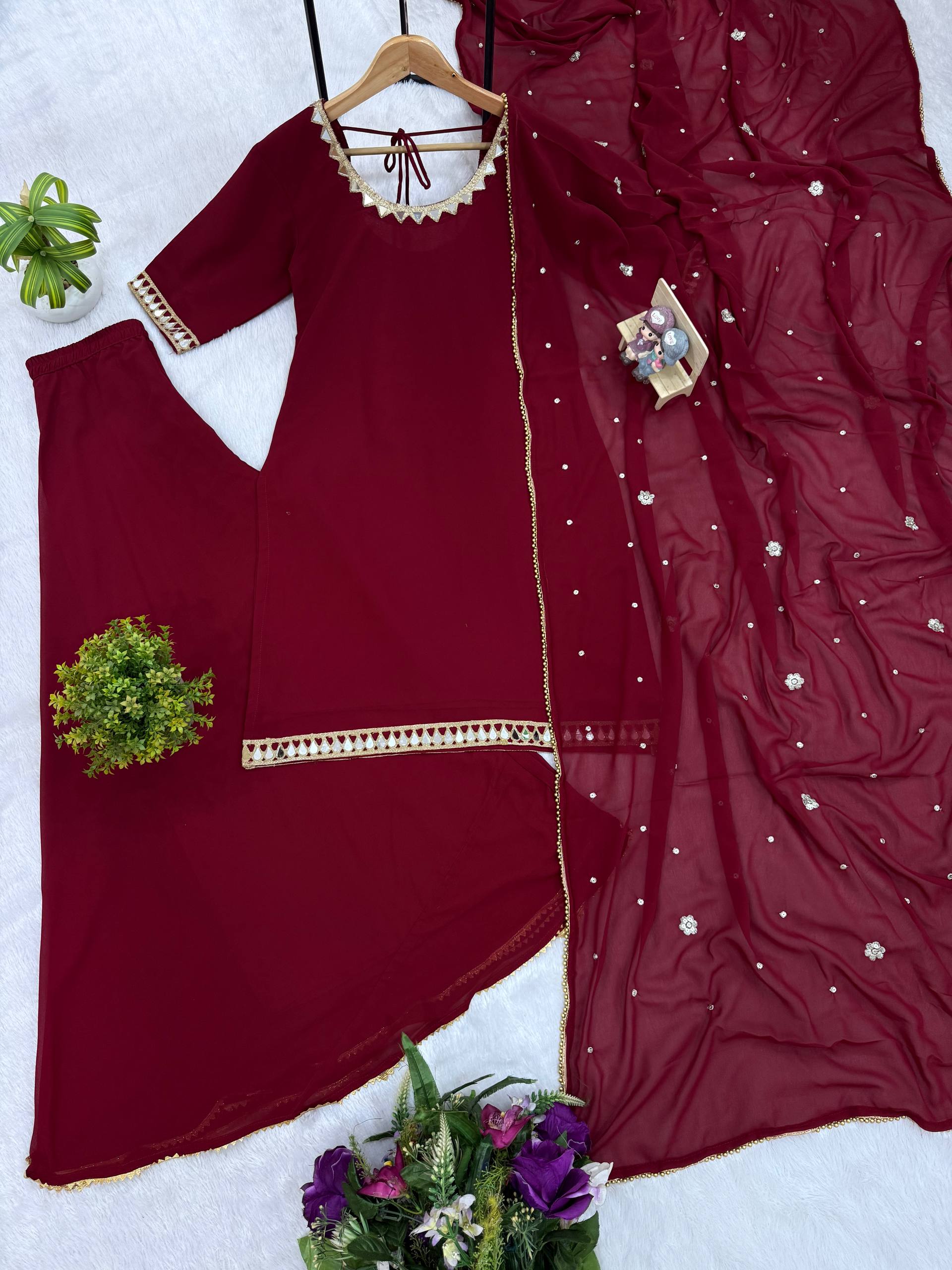 Maroon traditional outfit with embroidered details on a white background