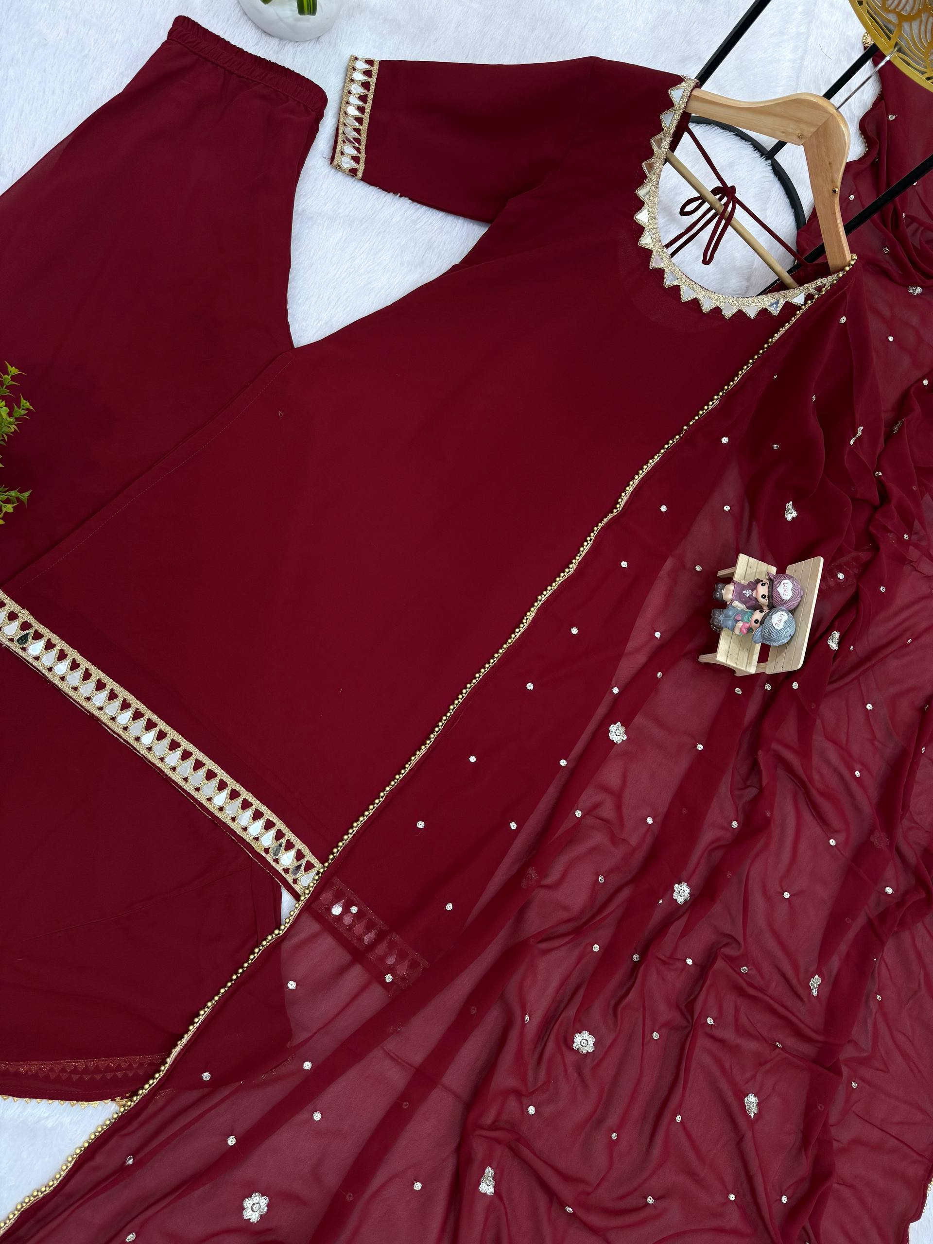 Maroon saree with gold border and floral embellishments on a white background