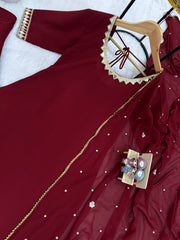 Red fabric with gold embroidery and decorative elements on a white background