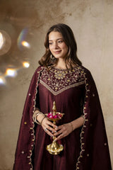 Woman in traditional attire holding a decorative lamp against a beige background