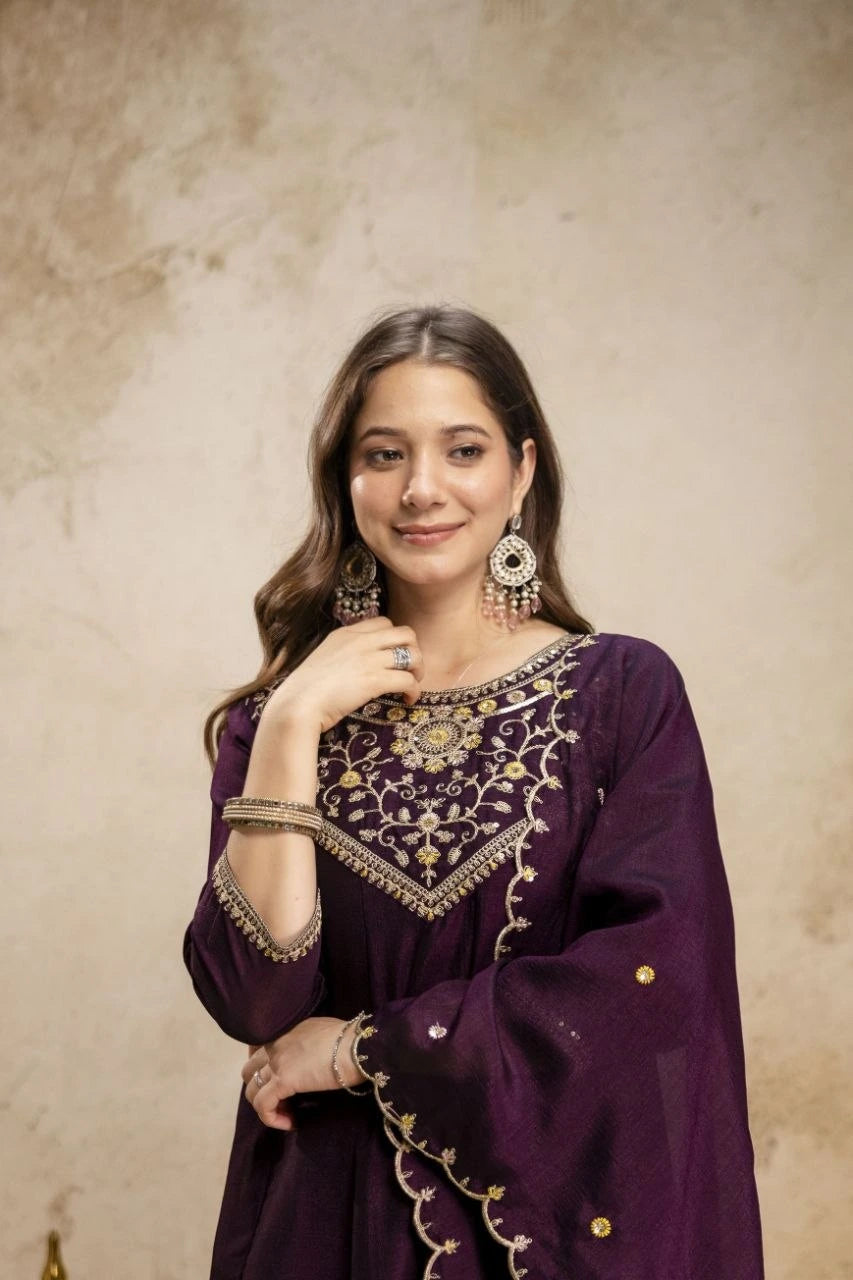 Woman wearing a purple embroidered outfit with gold details against a beige background