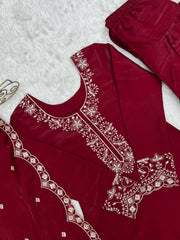 Maroon traditional outfit with white embroidery on a textured surface
