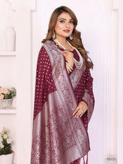 Woman wearing a maroon and white patterned shawl in a room with white walls and decor.