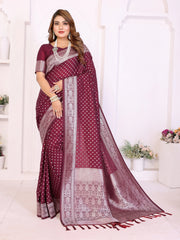 Woman wearing a maroon saree with white patterns in a bright room.