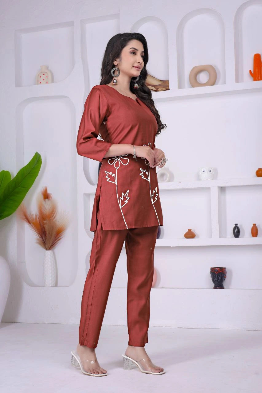 Woman wearing a red outfit with white patterns in a minimalistic setting