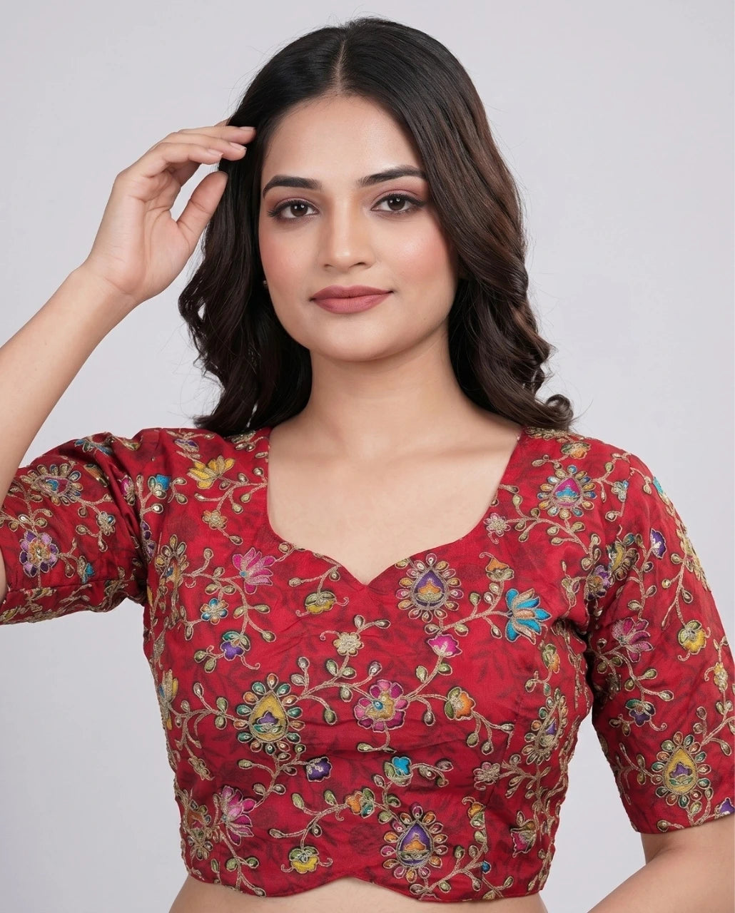 Woman wearing a red floral blouse against a plain background