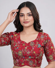Woman wearing a red floral blouse against a plain background
