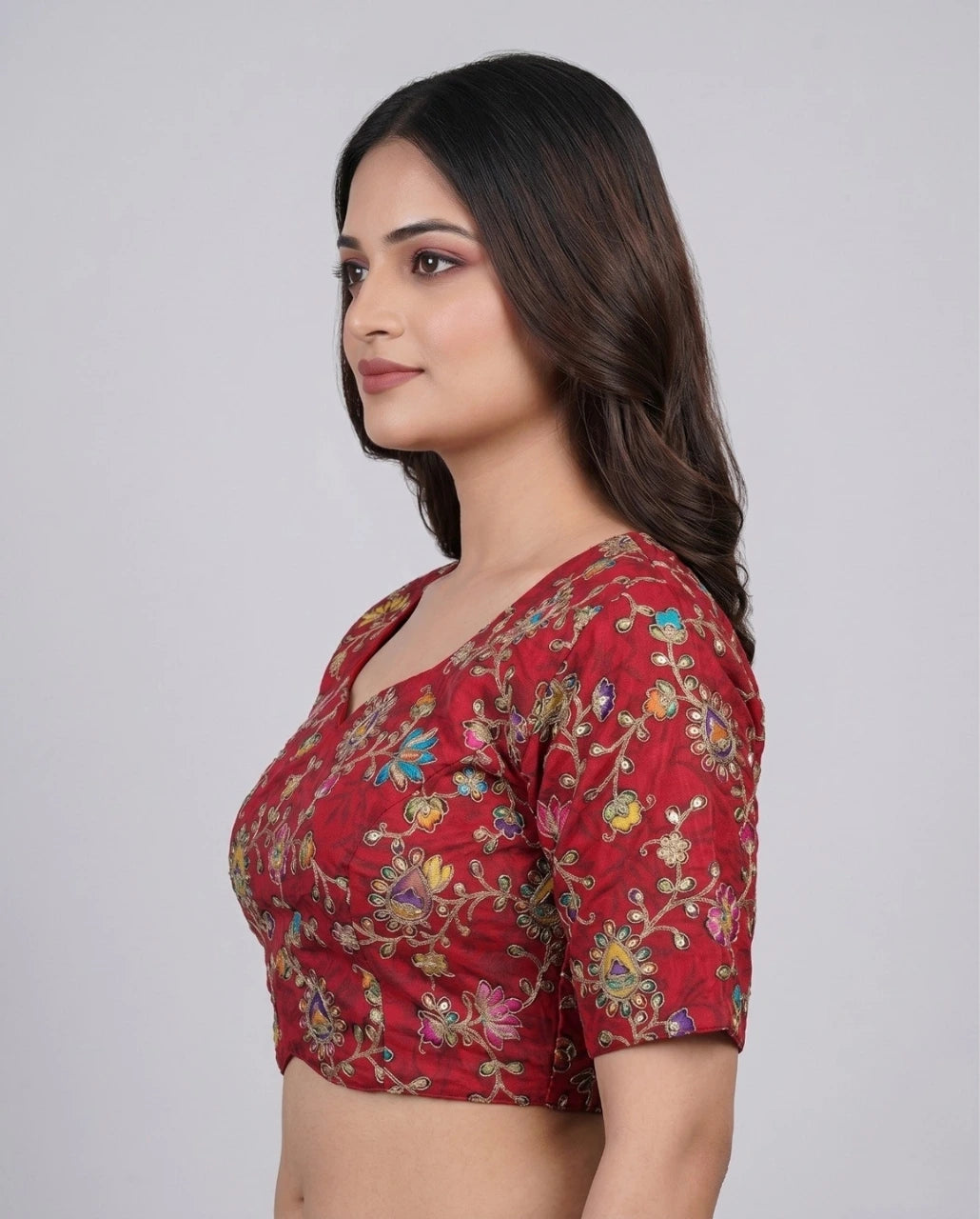 Woman wearing a red floral blouse against a white background