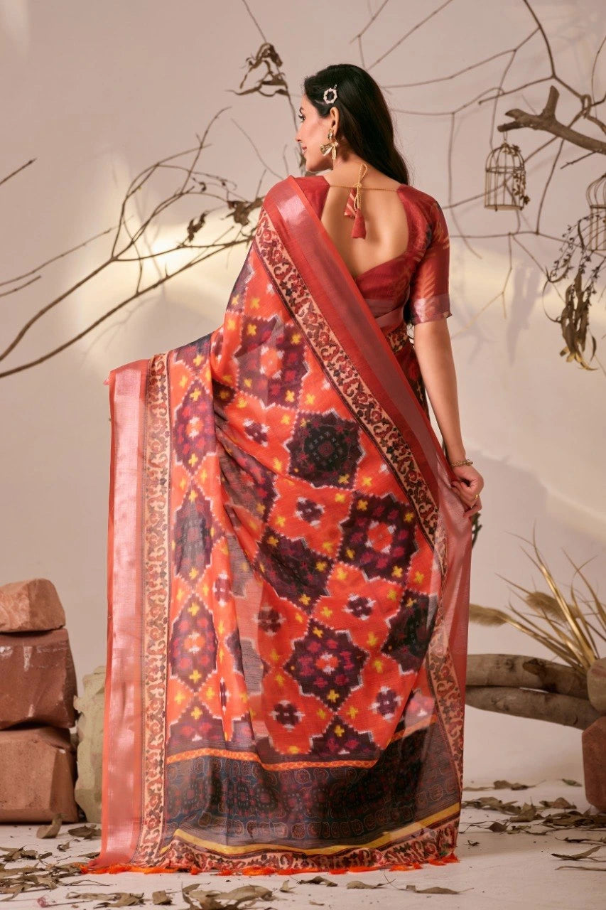 Woman wearing a traditional saree with intricate patterns in a decorative setting.