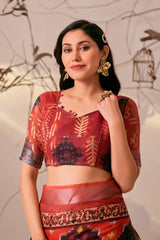 Woman wearing a traditional red and black patterned outfit with gold jewelry against a neutral background.