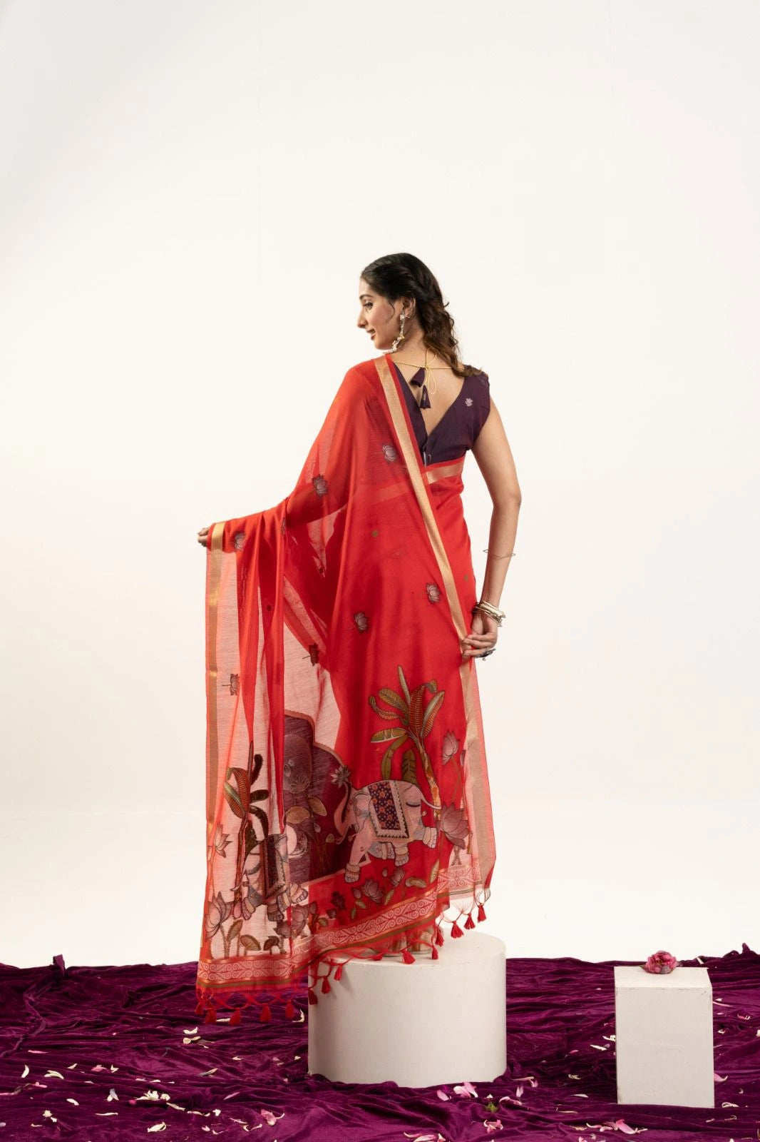 Woman wearing a red saree with a white background