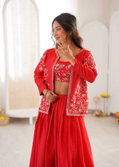 Woman wearing a red outfit with white embroidery in a minimal indoor setting