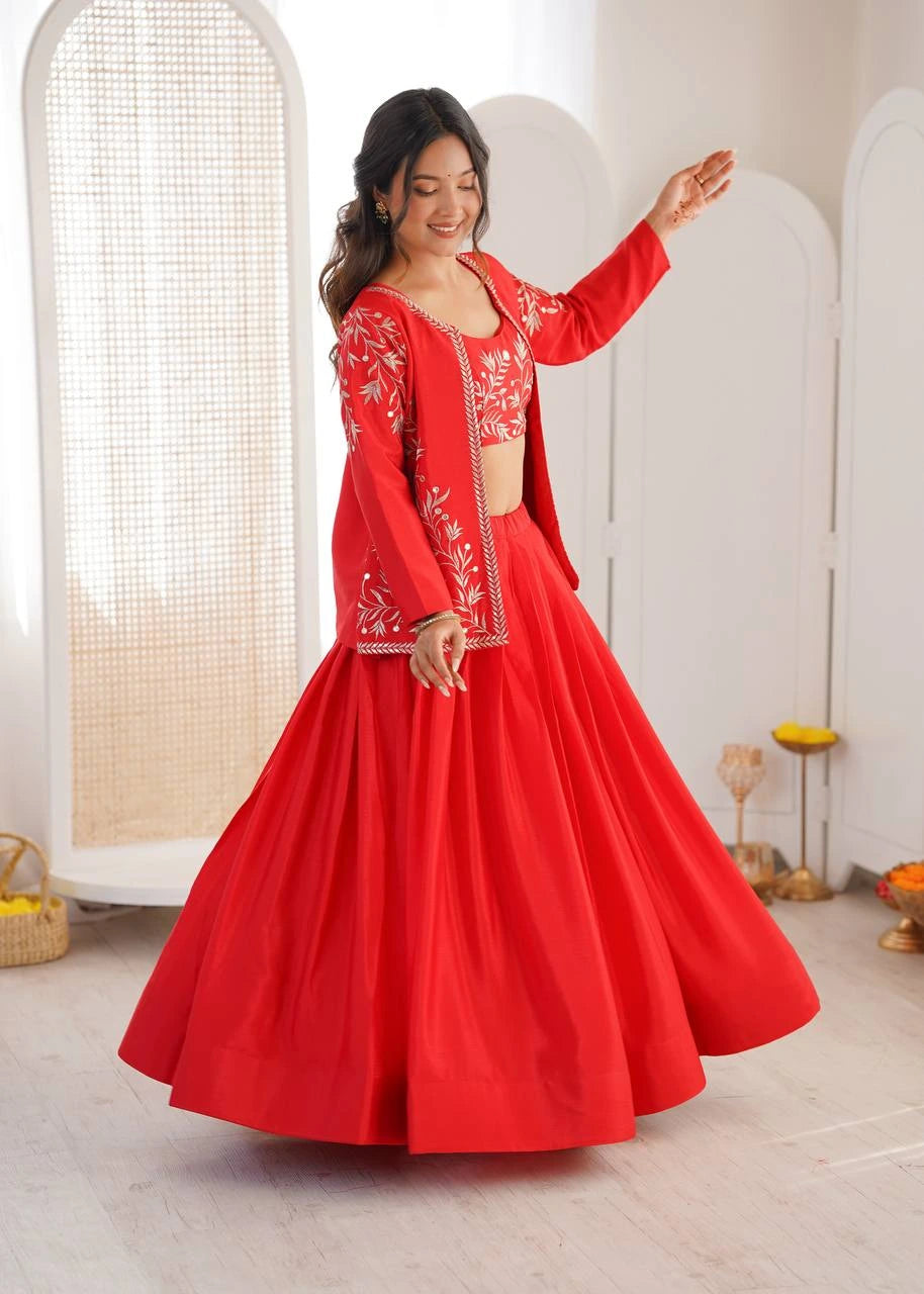 Woman in a red traditional outfit with white embroidery standing in a bright room.