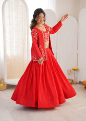 Woman in a red traditional outfit with white embroidery standing in a bright room.