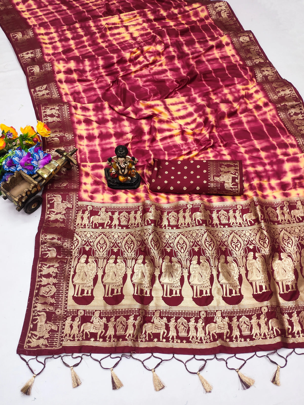 Maroon and gold saree with intricate patterns on a white background
