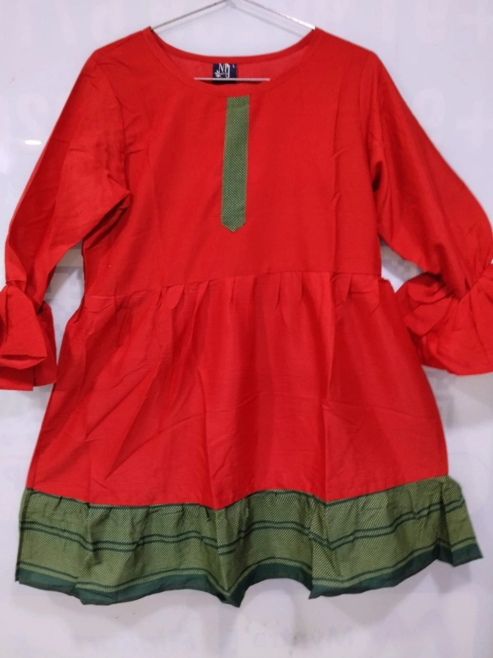 Red dress with green accents on a white background