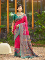 Woman wearing a pink saree with a patterned border outdoors.