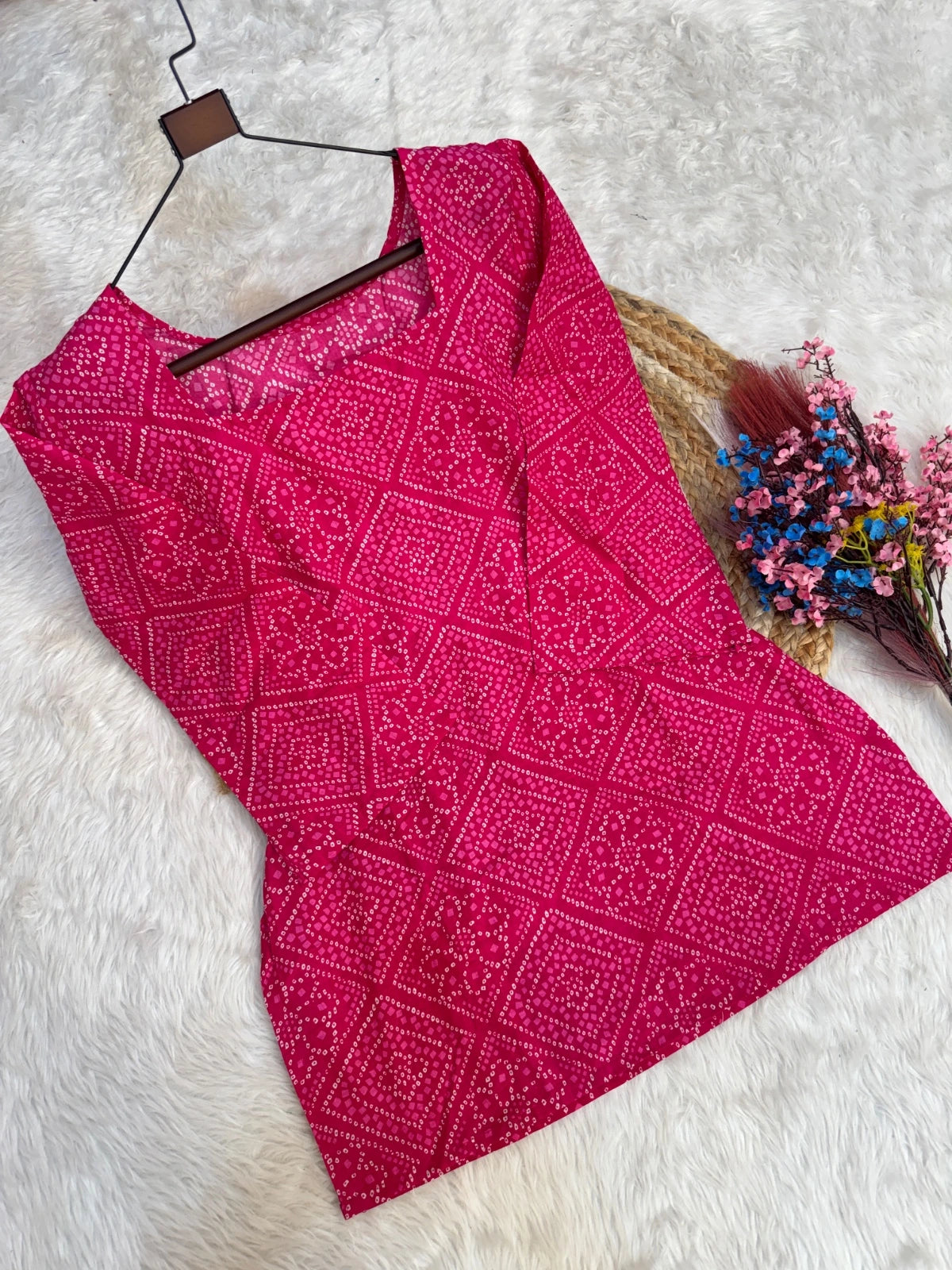 Pink patterned fabric on a hanger with a white background