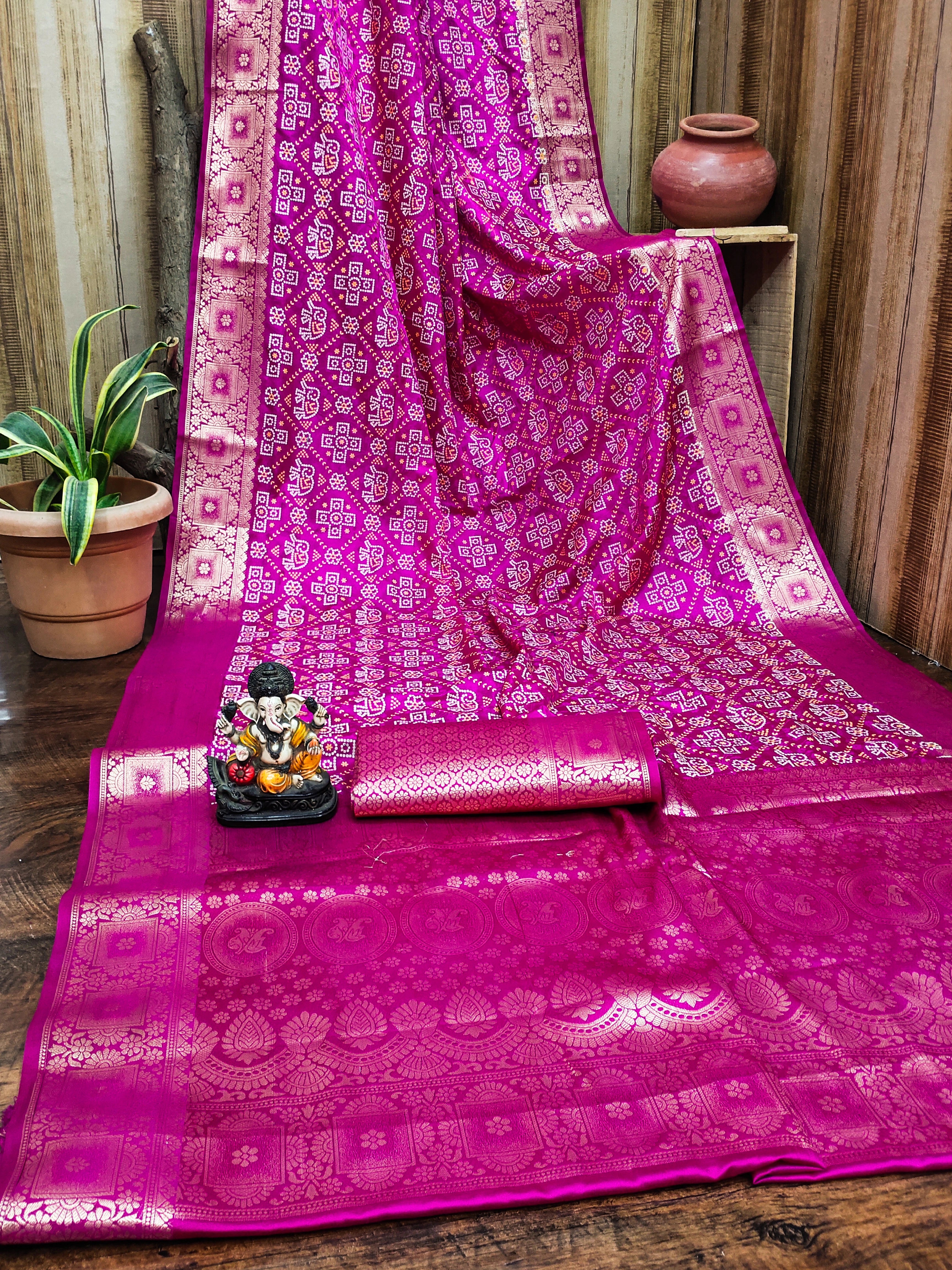 Pink saree with intricate patterns on a wooden surface