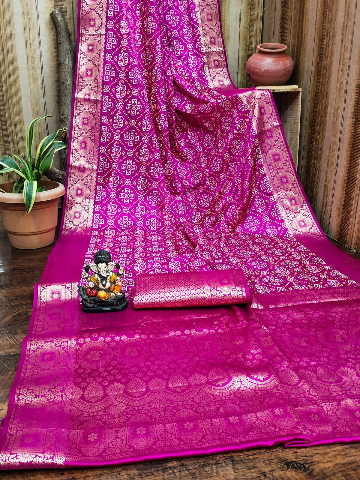Pink saree with intricate patterns on a wooden surface