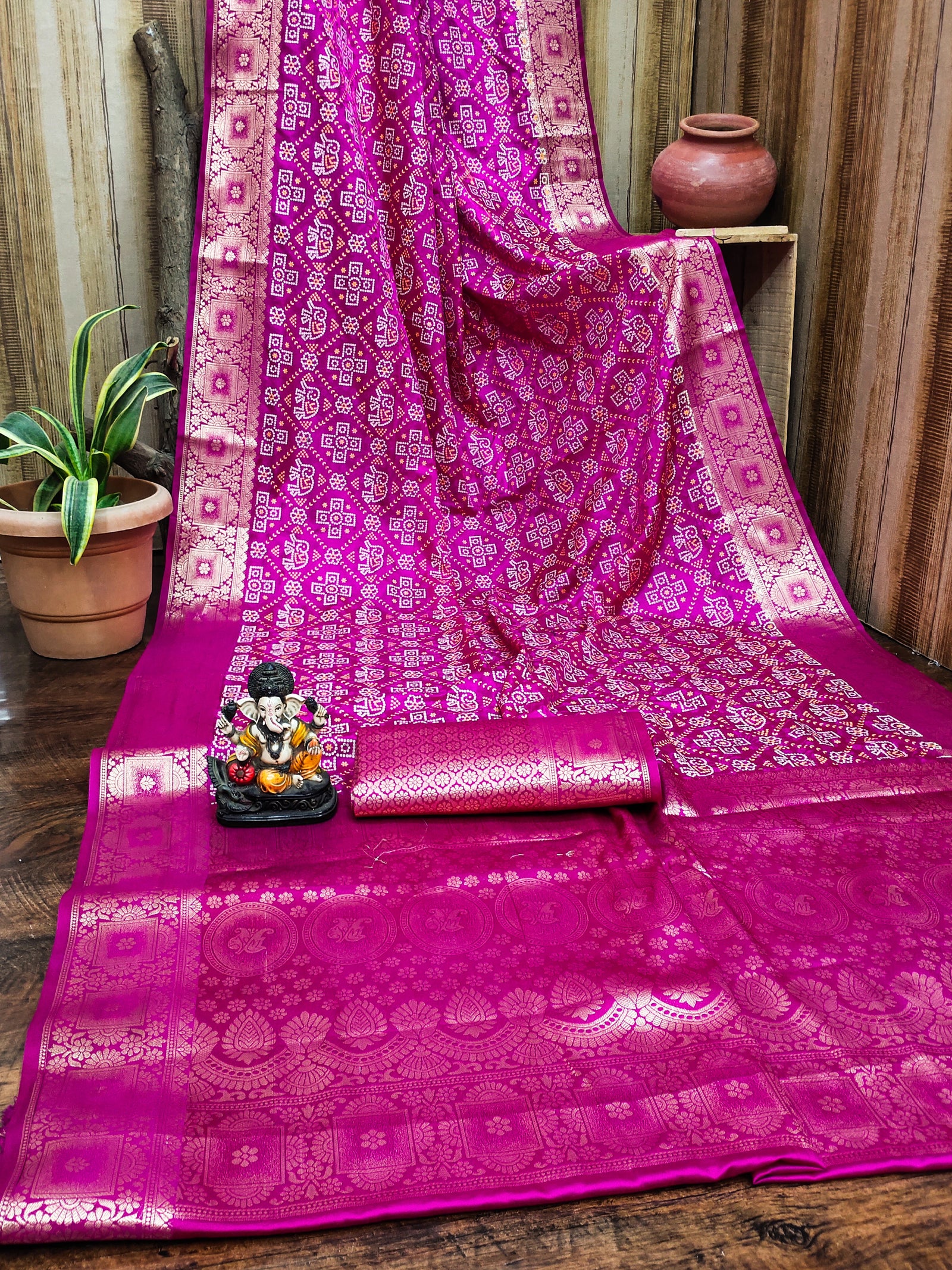 Pink saree with intricate patterns on a wooden surface