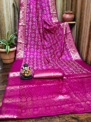 Pink saree with intricate patterns on a wooden surface