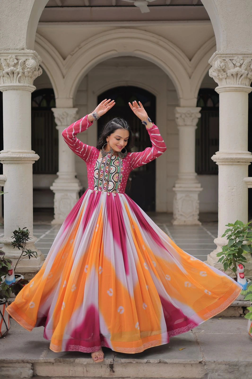 Woman in a colorful traditional dress dancing in an architectural setting