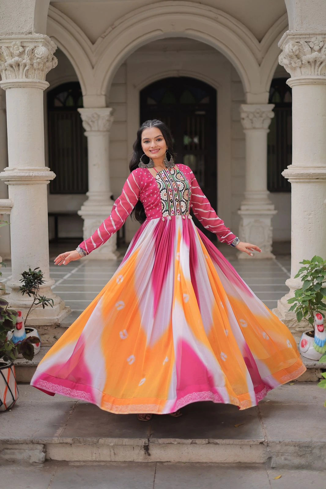 Woman in a colorful dress standing in an architectural setting with columns.
