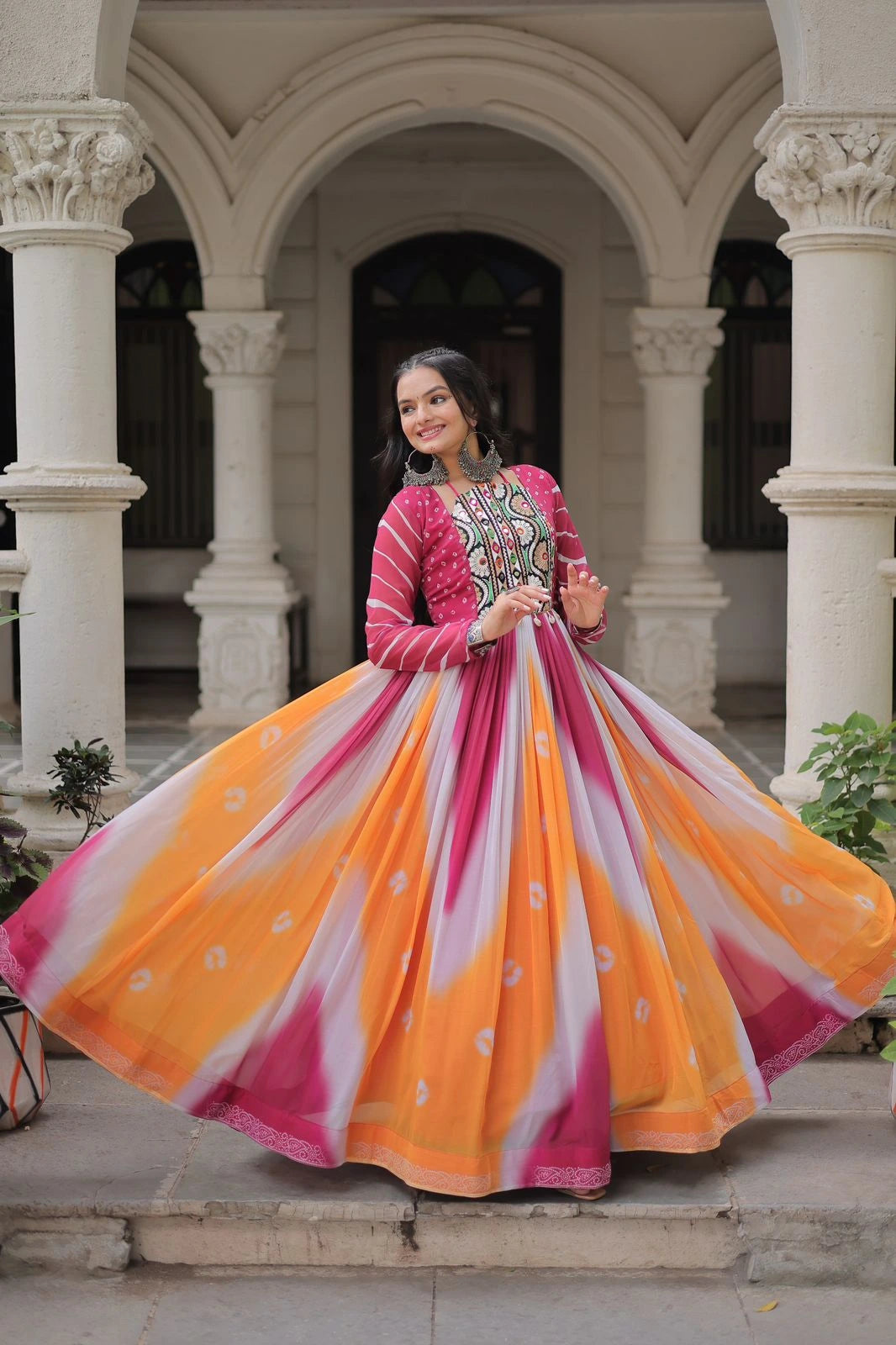 Woman in a colorful traditional outfit standing in an architectural setting