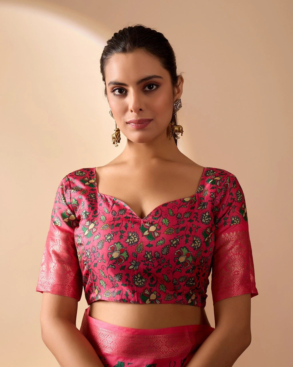 Woman wearing a pink blouse with floral patterns on a beige background