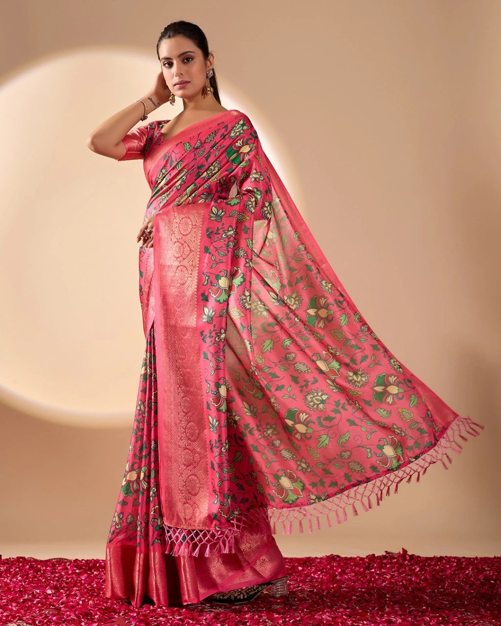 Woman wearing a pink saree with floral patterns on a beige background