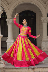 Woman in a pink and yellow traditional outfit performing in an elegant setting.