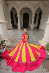 Woman in a pink and yellow dress standing in an architectural courtyard.