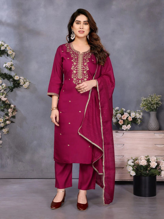 Woman wearing a magenta traditional outfit with floral decorations in the background
