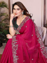 Woman wearing a pink saree with silver embroidery indoors.