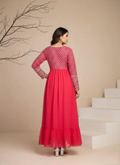 Woman wearing a red dress with white patterns in a minimalistic setting