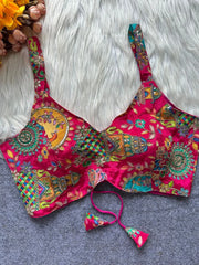 Colorful embroidered pink blouse with floral patterns on a textured surface