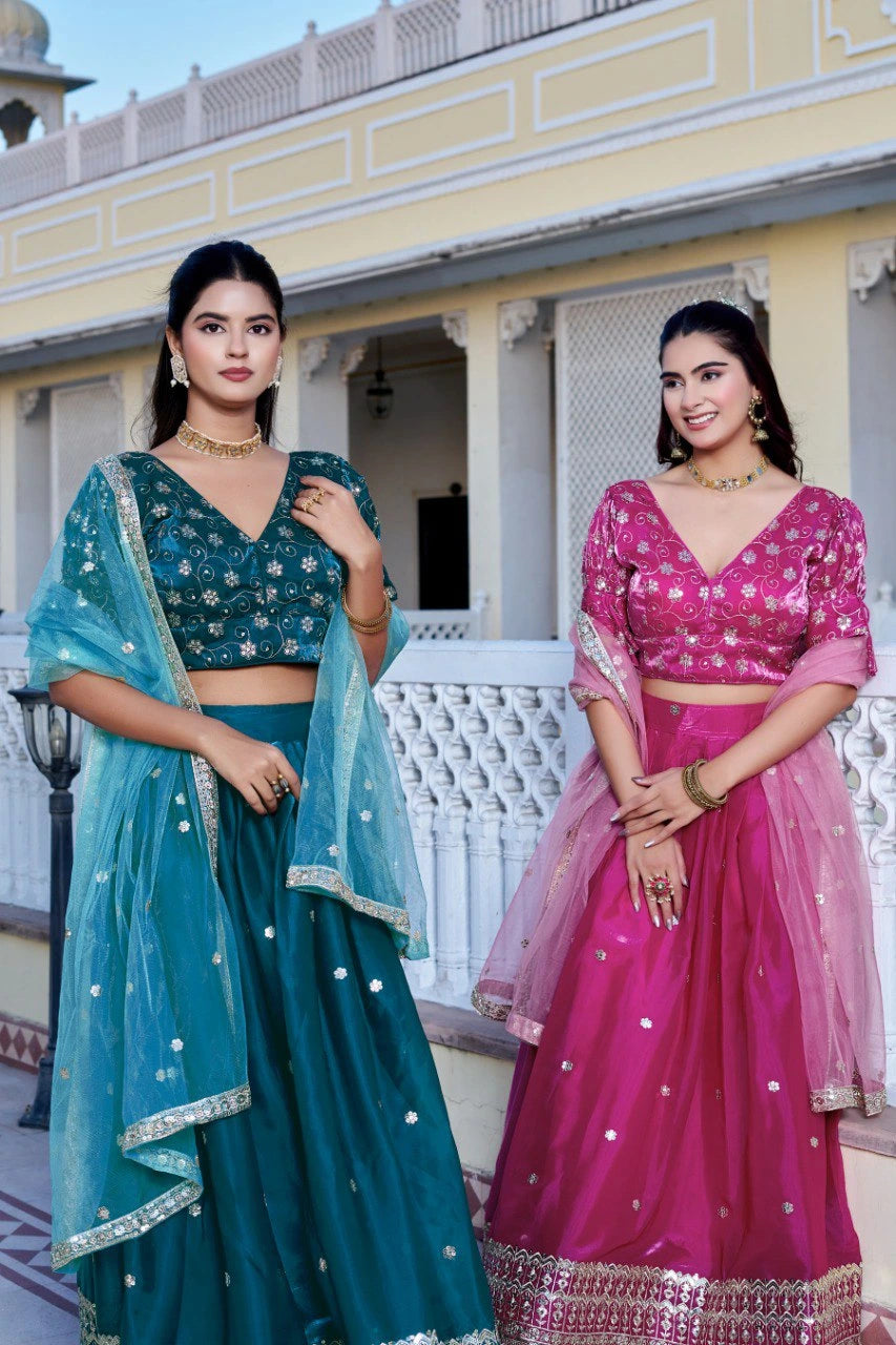 Two women in traditional outfits standing outdoors with a building in the background.