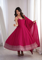 Woman wearing a pink traditional outfit with a matching dupatta in a bright room.