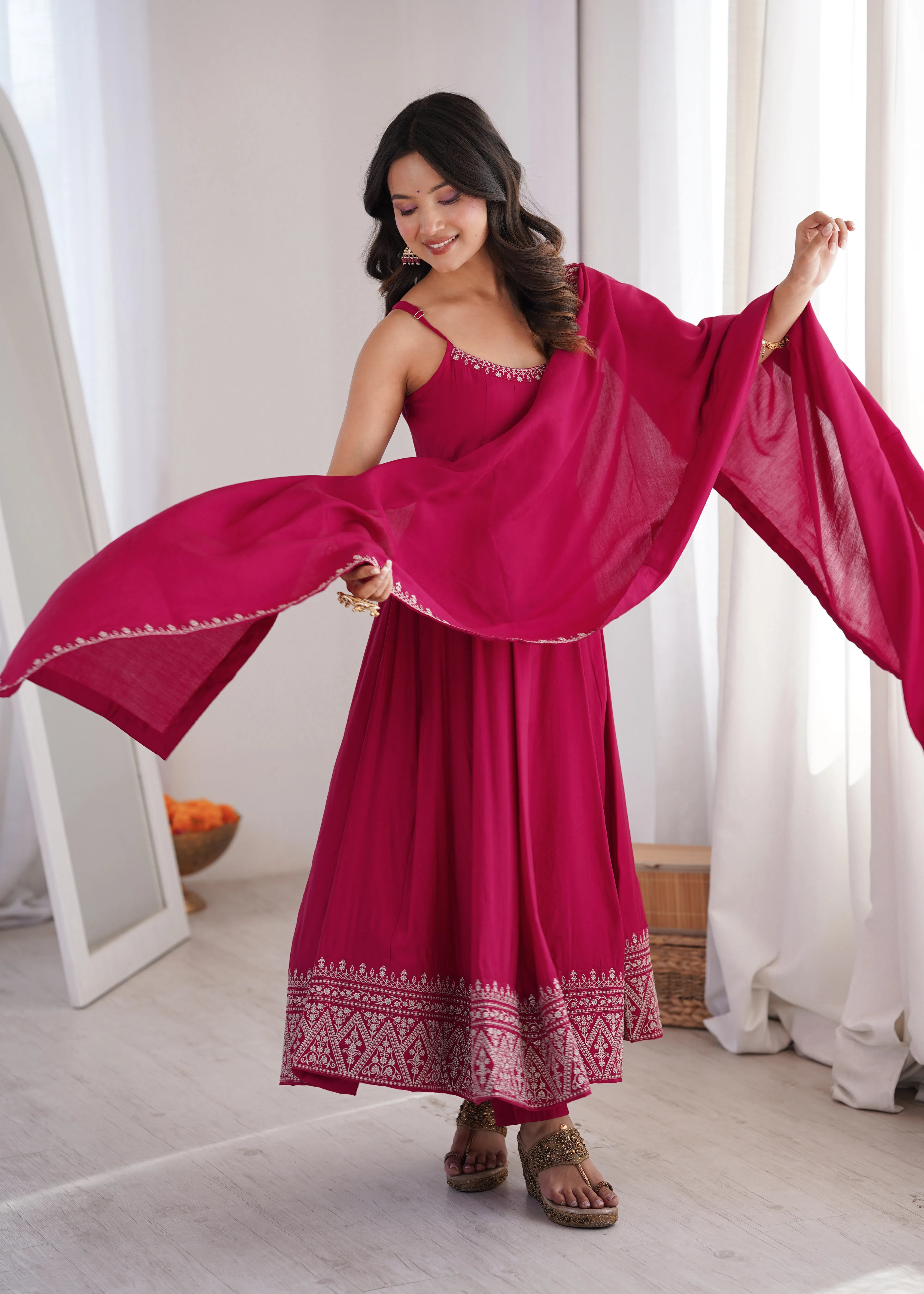 Woman in a red dress with a matching shawl in a bright room.