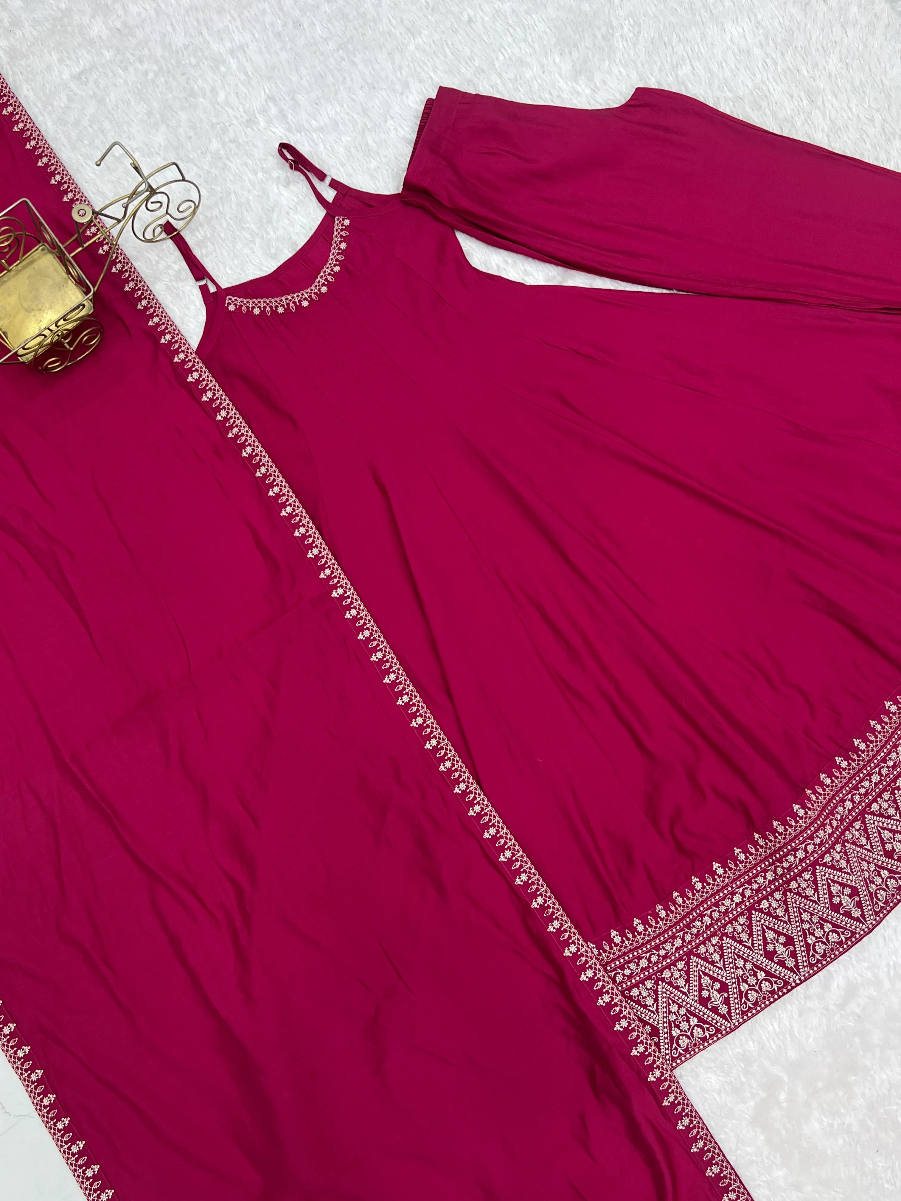 Maroon traditional outfit with intricate border on a white background