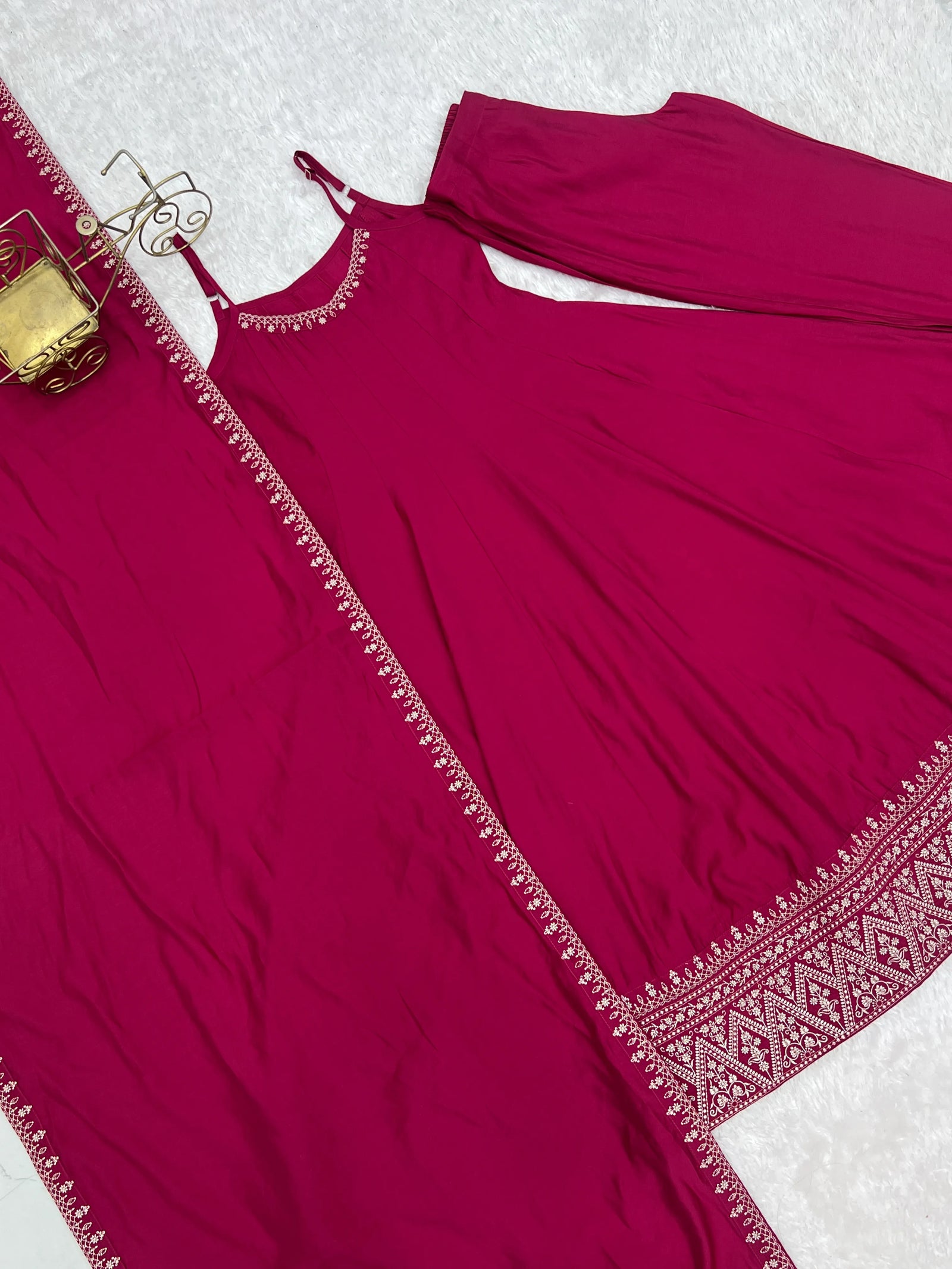 Maroon traditional outfit with intricate border on a white background