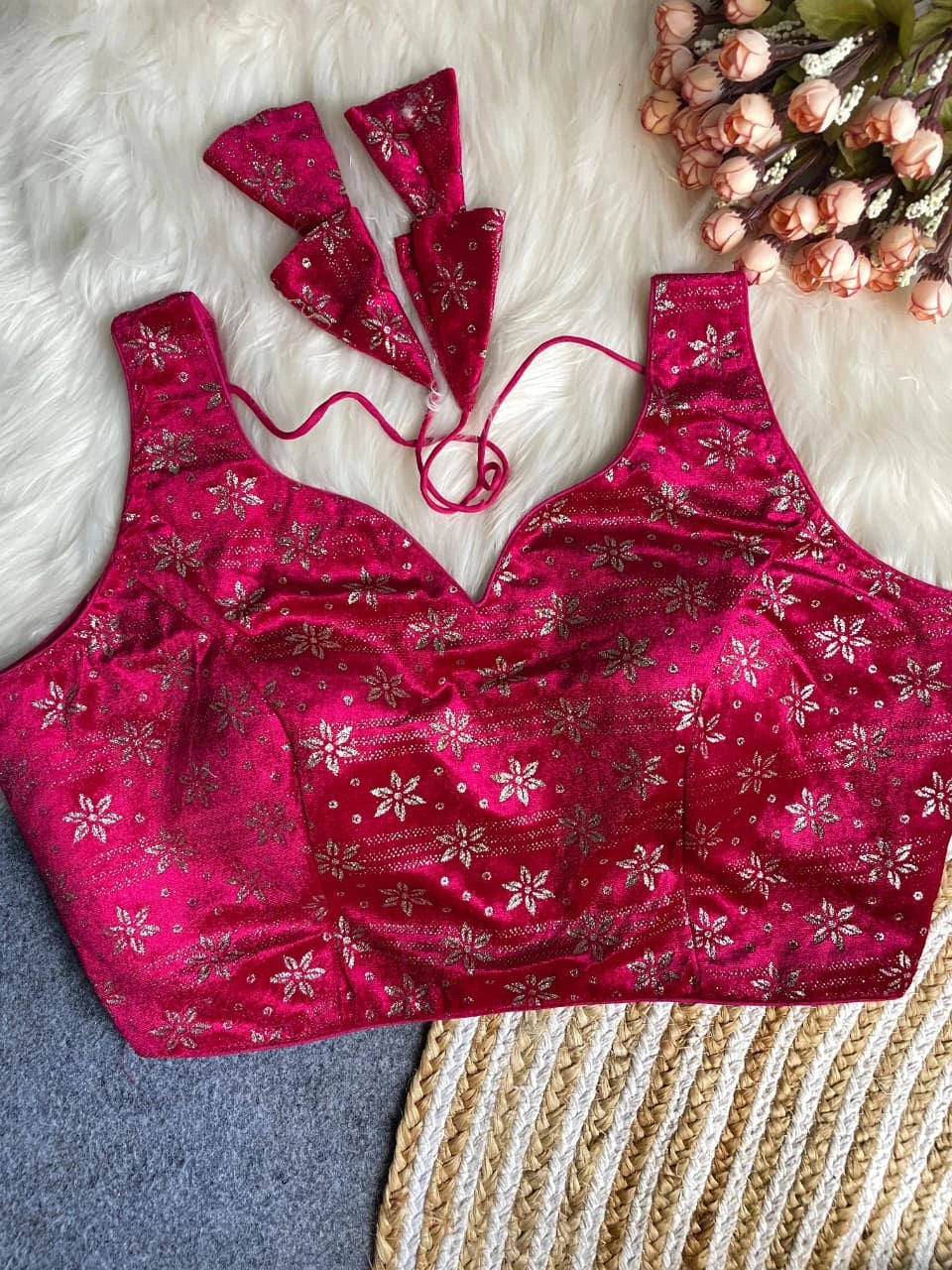 Pink patterned bralette with matching underwire and floral headbands on a textured surface.