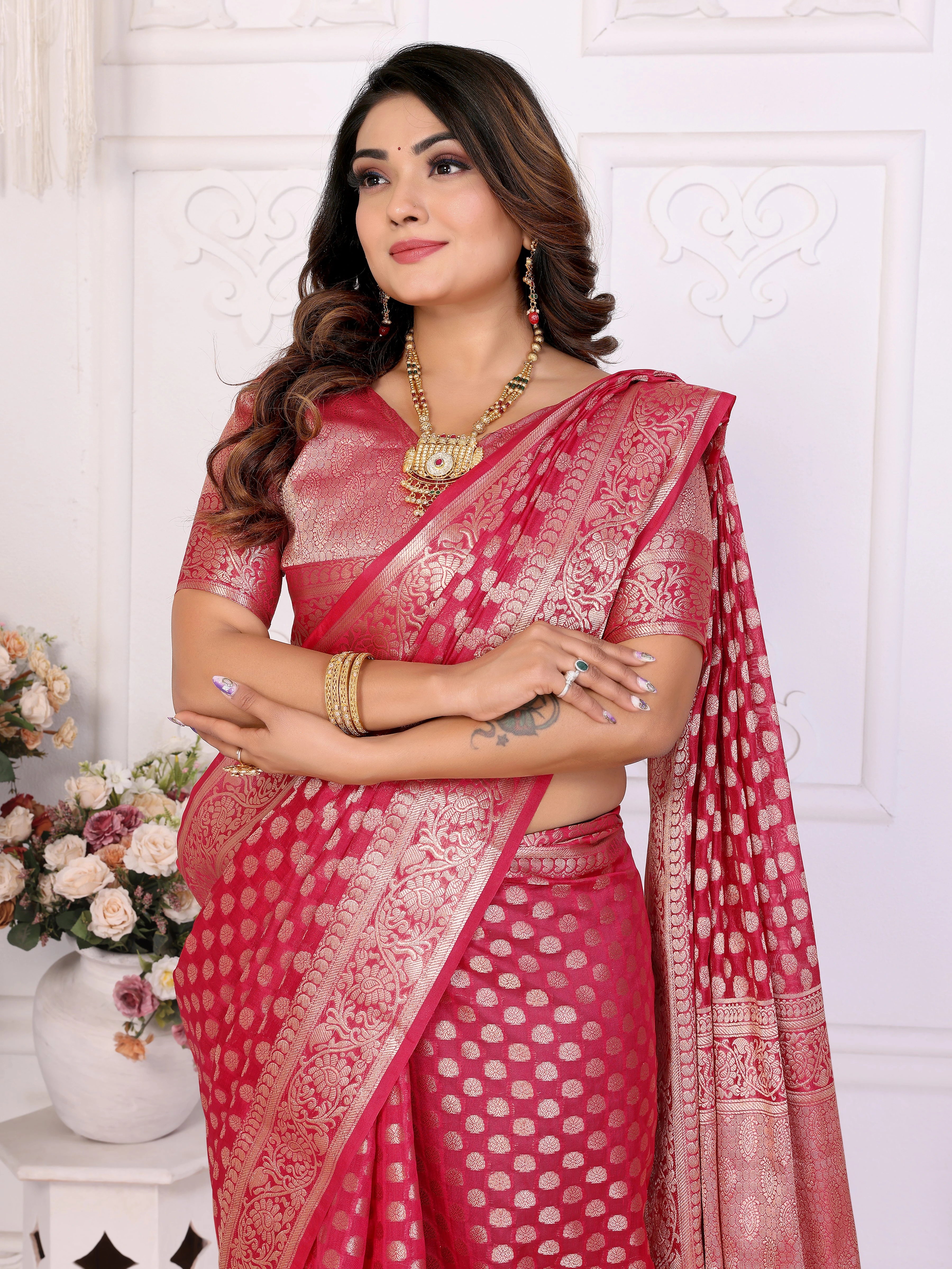 Woman wearing a red saree with a white pattern against a white background