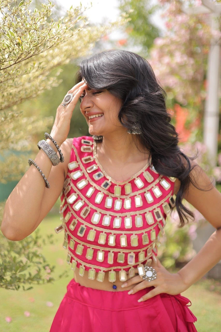 Elegant pink lehenga choli featuring a sleeveless mirror work blouse and a flared skirt with bold golden polka dot motifs.