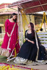 Two women in traditional attire sitting on a swing decorated with flowers.