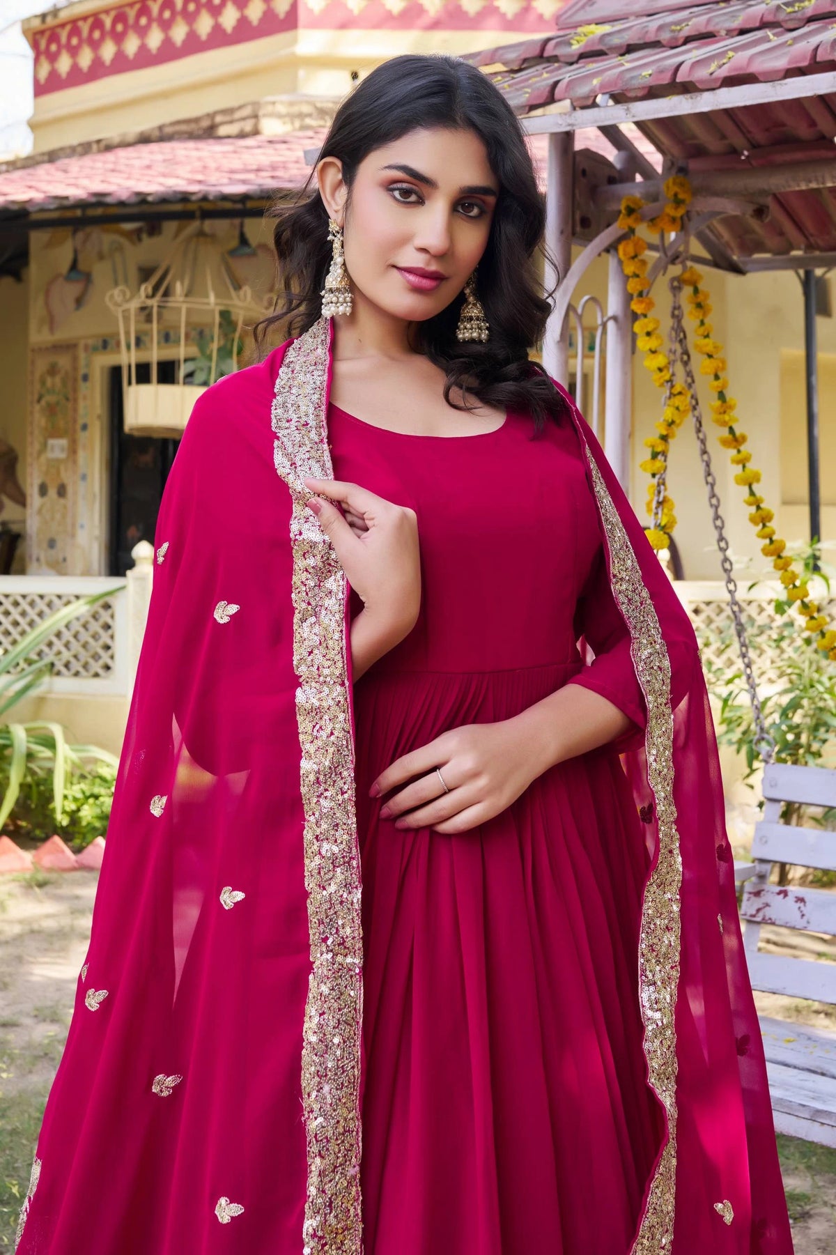 Woman in a red traditional outfit with a pink dupatta in an outdoor setting