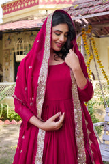 Woman in a red traditional outfit with a matching dupatta outdoors.